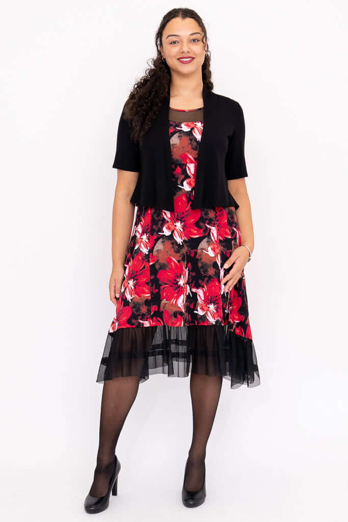 Woman in floral dress with mesh hem, paired with black short-sleeve cardigan