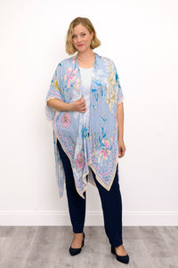 Front view of woman wearing a light blue floral kimono on a white top and navy pants against a white background