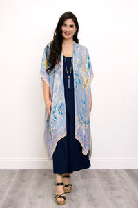 Front view of woman wearing a light blue floral kimono on a navy outfit against a white background