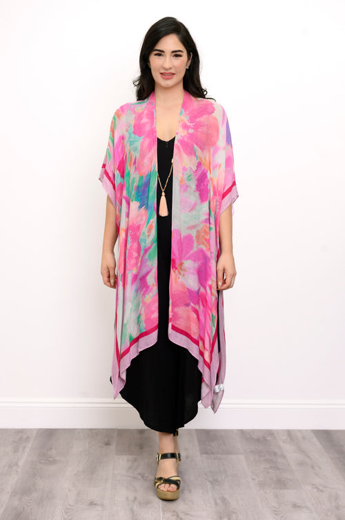 Front view of woman wearing pink multicolor floral patterned kimono on a black outfit against a white background