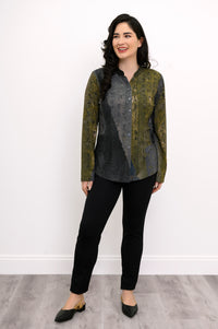 Woman wearing a green and grey patterned top and black pants on a white background, front view