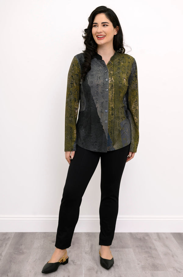 Front view of a female model wearing a khaki green and grey top with black pants and black heels against a white background and grey floor