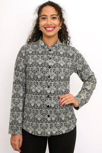 Smiling woman modeling a patterned charcoal grey long sleeve blouse with a mandarin collar and black pants
