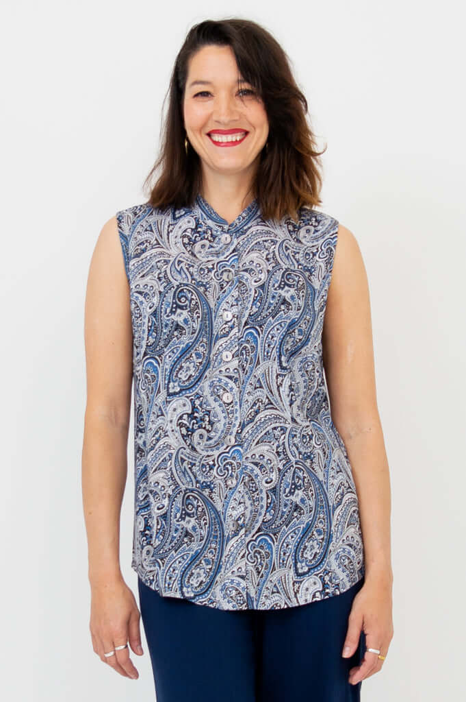 Woman wearing the Debbie Tank, a sleeveless paisley blouse with a Mandarin collar and button-down front