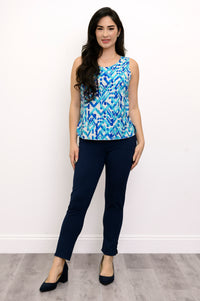 Front view of woman wearing a blue patterned sleeveless top and navy pants against a white background
