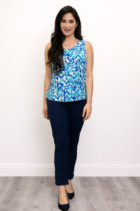 Front view of woman wearing a blue patterned sleeveless top and navy pants against a white background