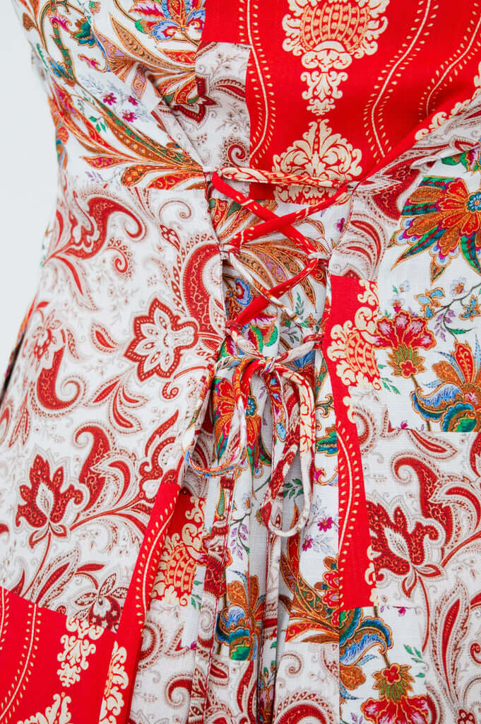Close-up of Anna dress red paisley fabric and back adjustable corset tie detail