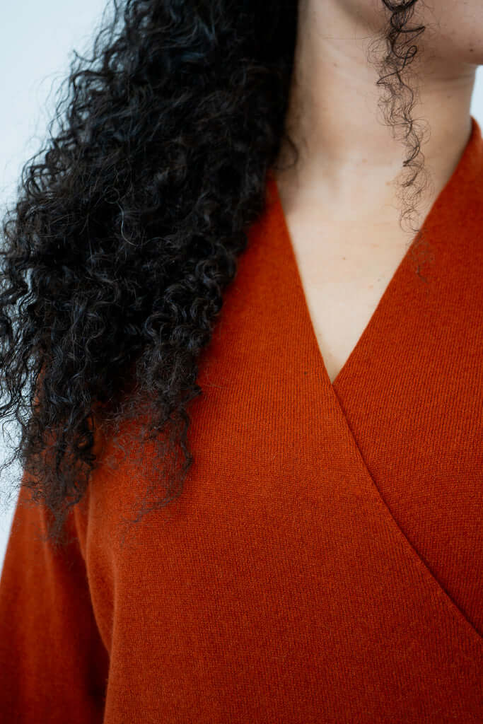 Close-up of rust cashmere surplice neckline sweater fabric