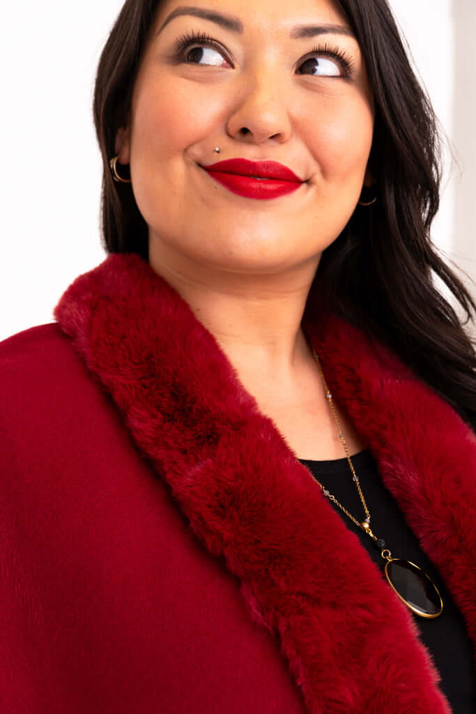 Close-up of faux fur collar on red wrap and necklace detail