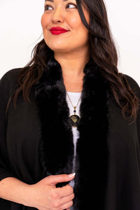 Close-up of faux fur collar and necklace detail on black wrap