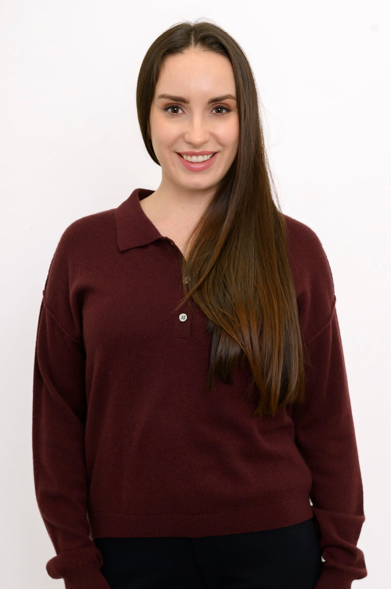 Close-up front view of woman wearing dark burgundy sweater with classic collar and 1/4 buttons