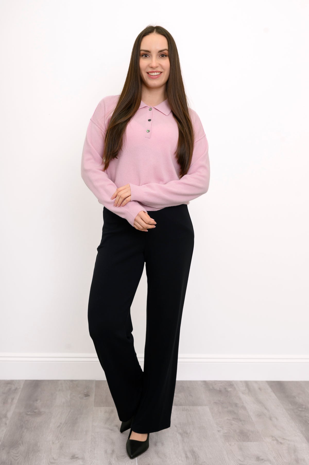 full body front view of woman wearing a ballerina pink jumper with black relaxed fit pants