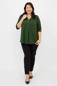 Woman walking forward in Edwina dark green bamboo top and black pants