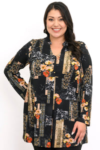 Close-up of a smiling woman in a black and orange floral bamboo tunic with a mandarin collar and V-neckline.
