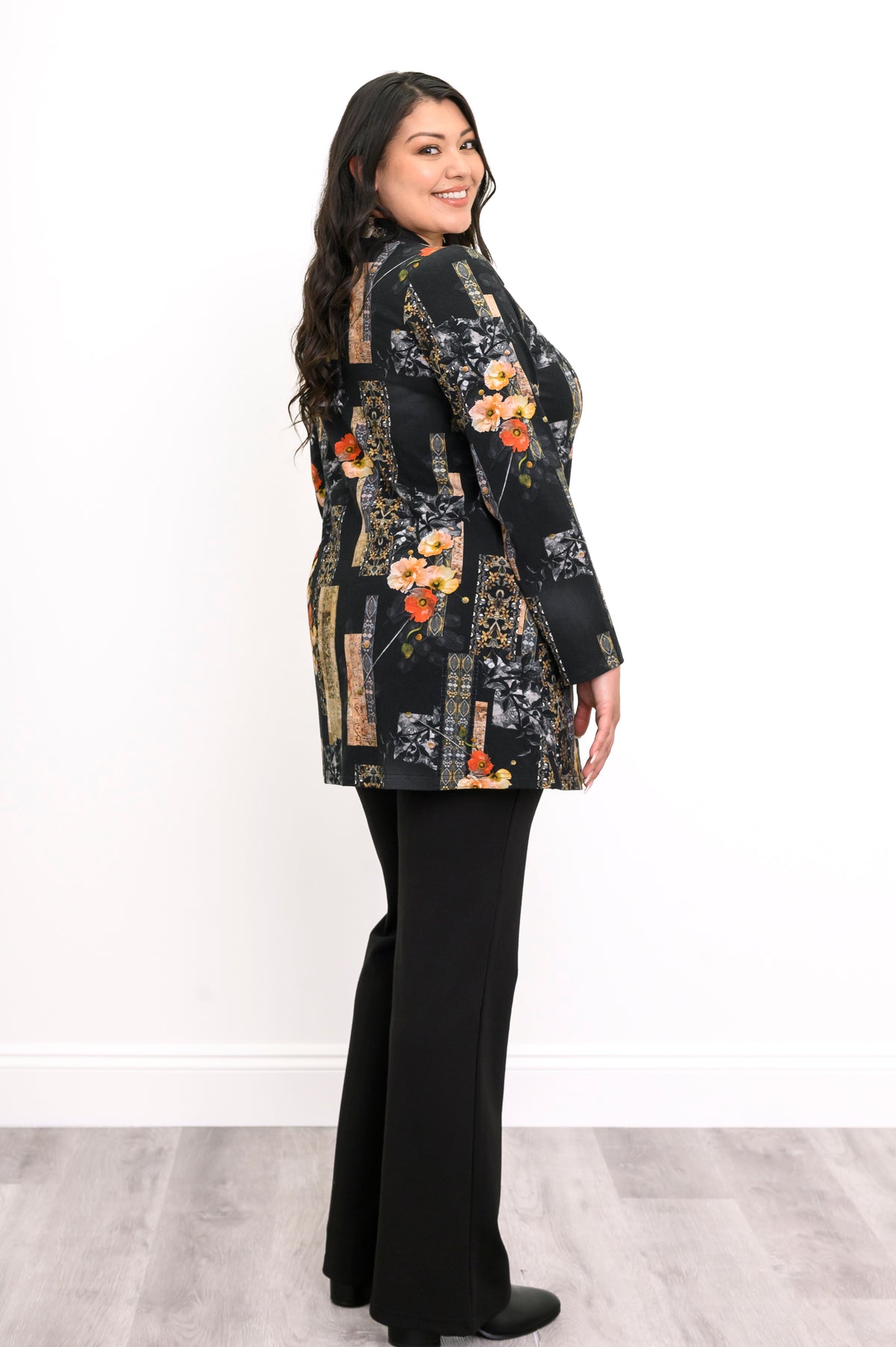 Side view of a woman wearing a black and orange floral long sleeve top, highlighting the comfortable, loose fit.