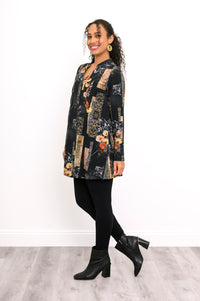 Three-quarter profile of a gold and black patterned bamboo top styled with fitted black trousers.