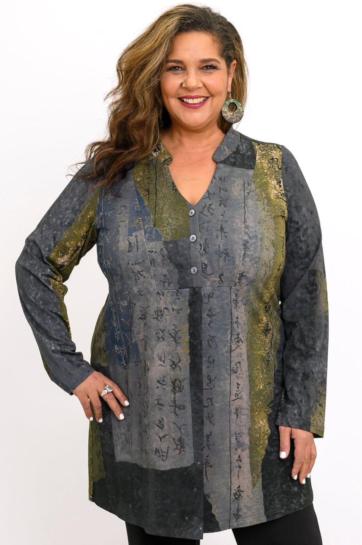 Model in a patterned olive-grey bamboo V-neck tunic featuring a three-button placket and long sleeves.