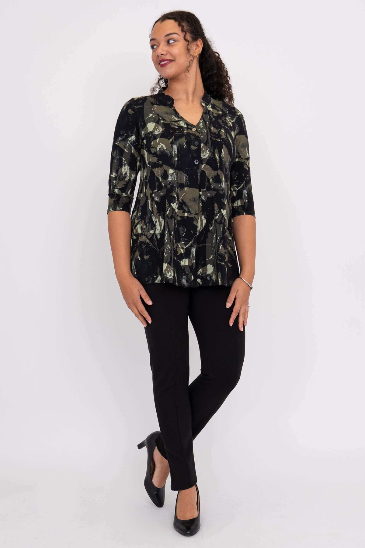Woman looking sideways wearing the Edwina bamboo top with black and olive abstract pattern