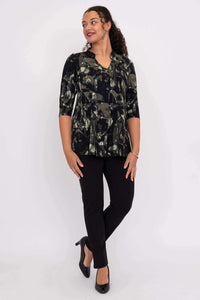 Woman looking sideways wearing the Edwina bamboo top with black and olive abstract pattern