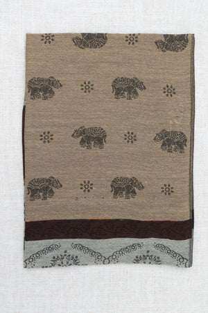 Folded pashmina scarf featuring intricate elephant and floral motifs on a beige background
