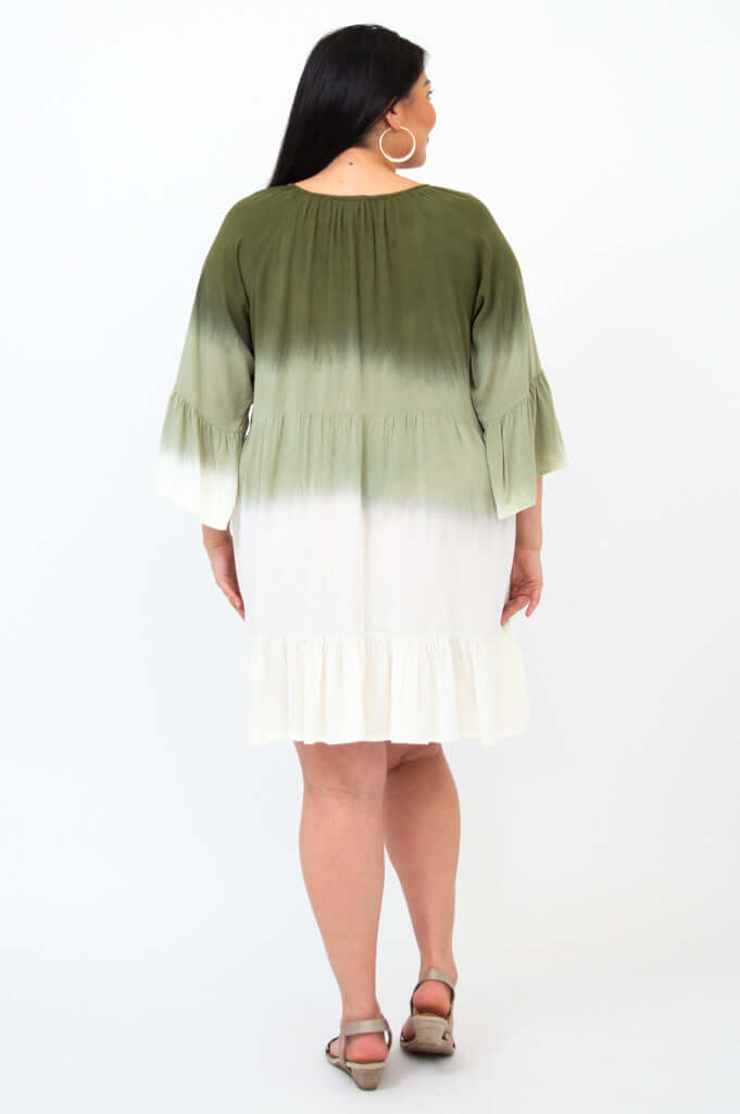 Back view of a woman in an olive green and white ombre dress with ruffle hem and 3/4 sleeves