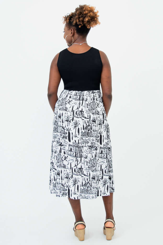Back view of woman wearing a sleeveless black and white empire waist midi dress