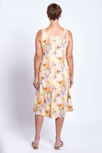 Back view of woman wearing a pastel tank dress with bird print