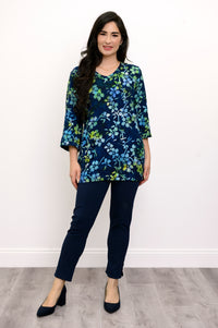 Woman wearing a blue and green floral top and navy pants against a white background, front view