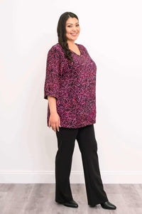 Side view of woman modeling Evelyn Top in pink and black leaf print