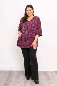 Woman posing in Evelyn Top, one hand in pocket, styled with black trousers