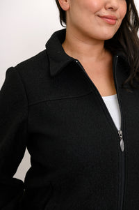 Close-up front view of woman's jacket showing collar, boiled wool texture, and zipper