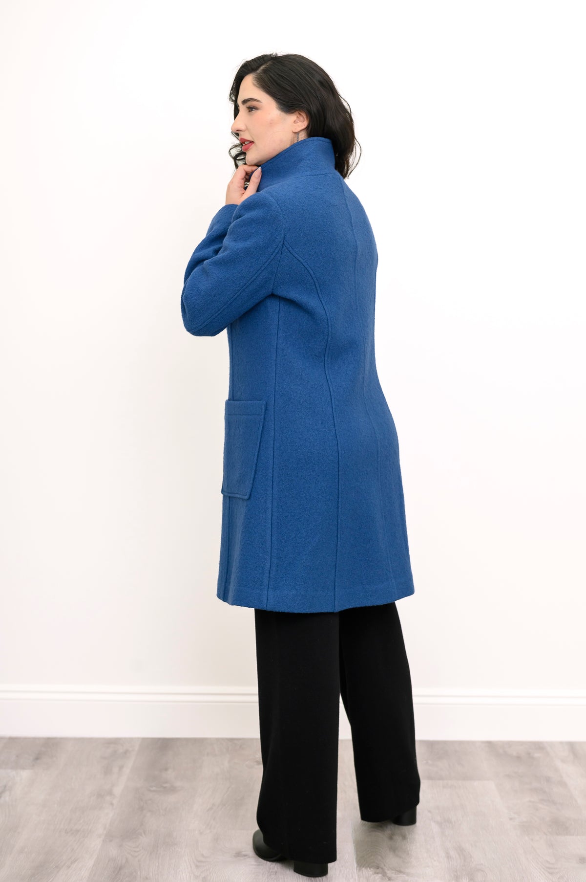 Back view of woman modelling long coat with pockets in cobalt blue boiled wool fabric