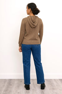Full body back view of woman wearing brown hoodie with jeans and black boots