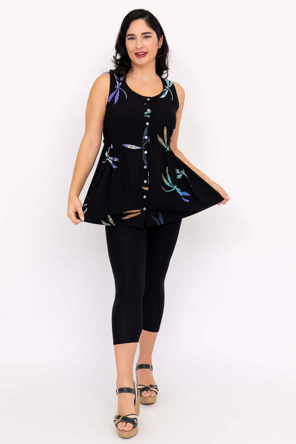 Woman displaying flared shape of black batik tank top with dragonfly print and button detail