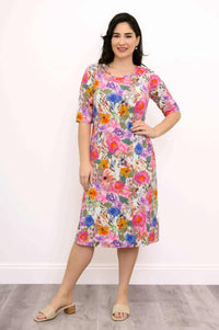 Woman modeling a floral bamboo dress, hand on hip, front view
