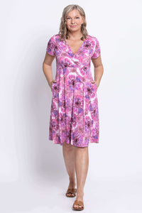 Woman posing with hands in pockets, wearing pink purple floral bamboo dress