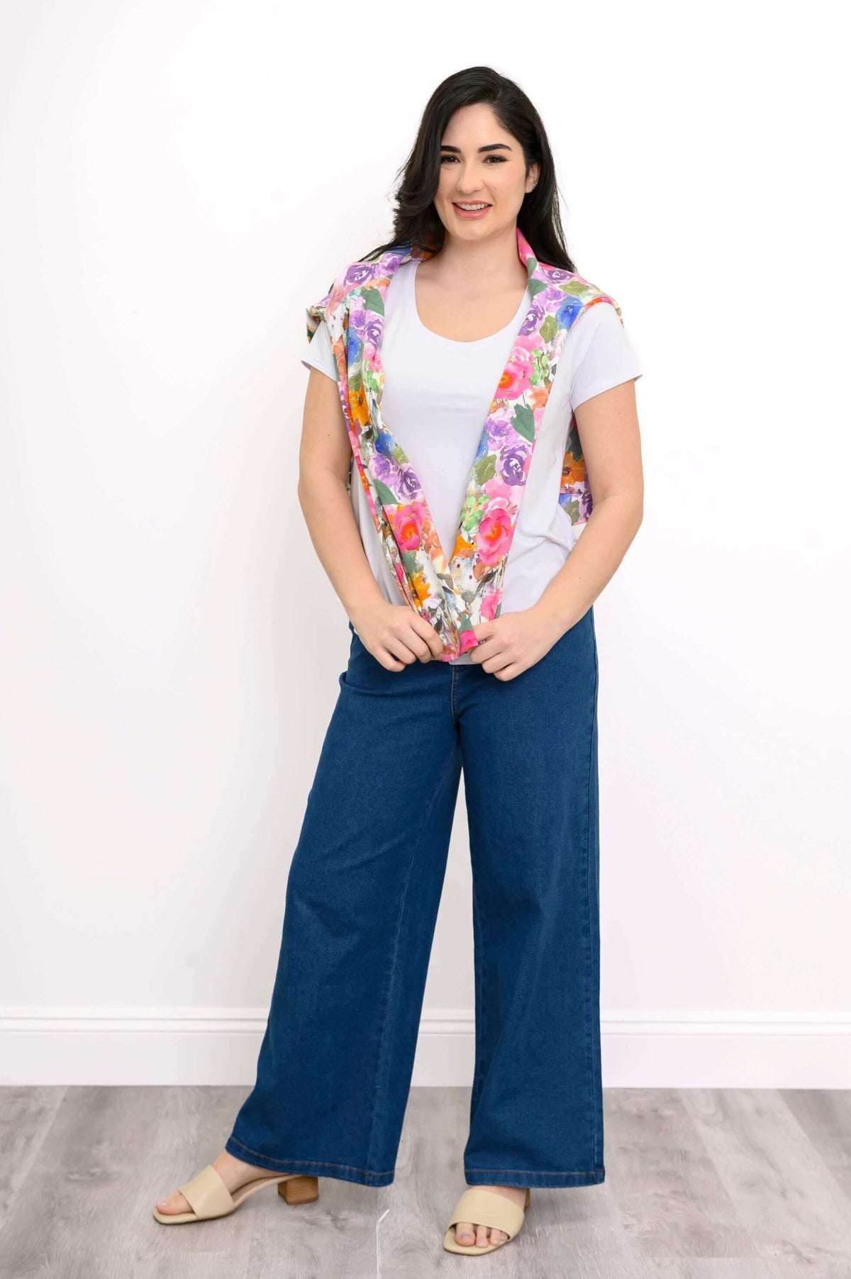 Woman drapes the floral jacket over her shoulders, showing its inner lining