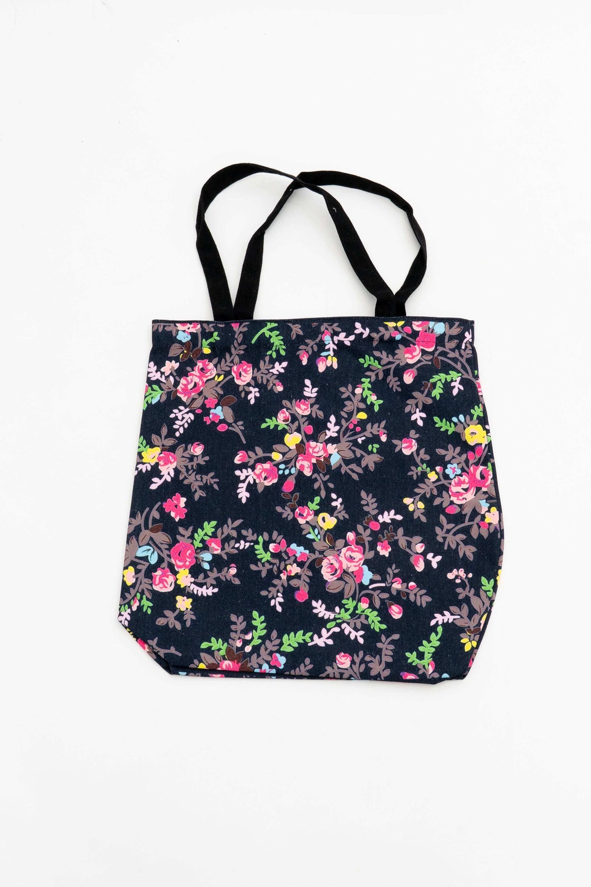 Reusable cotton tote bag with a colorful floral camouflage print on a dark background