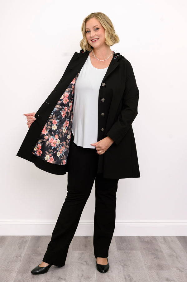 Front view of a woman wearing a black button down modal coat featuring a floral lined hood in studio.