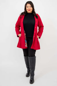 Full-body view of a person in a berry red swing coat with the coat open