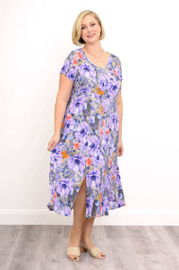 Woman posing in a flowing purple floral Morgan dress with side slits