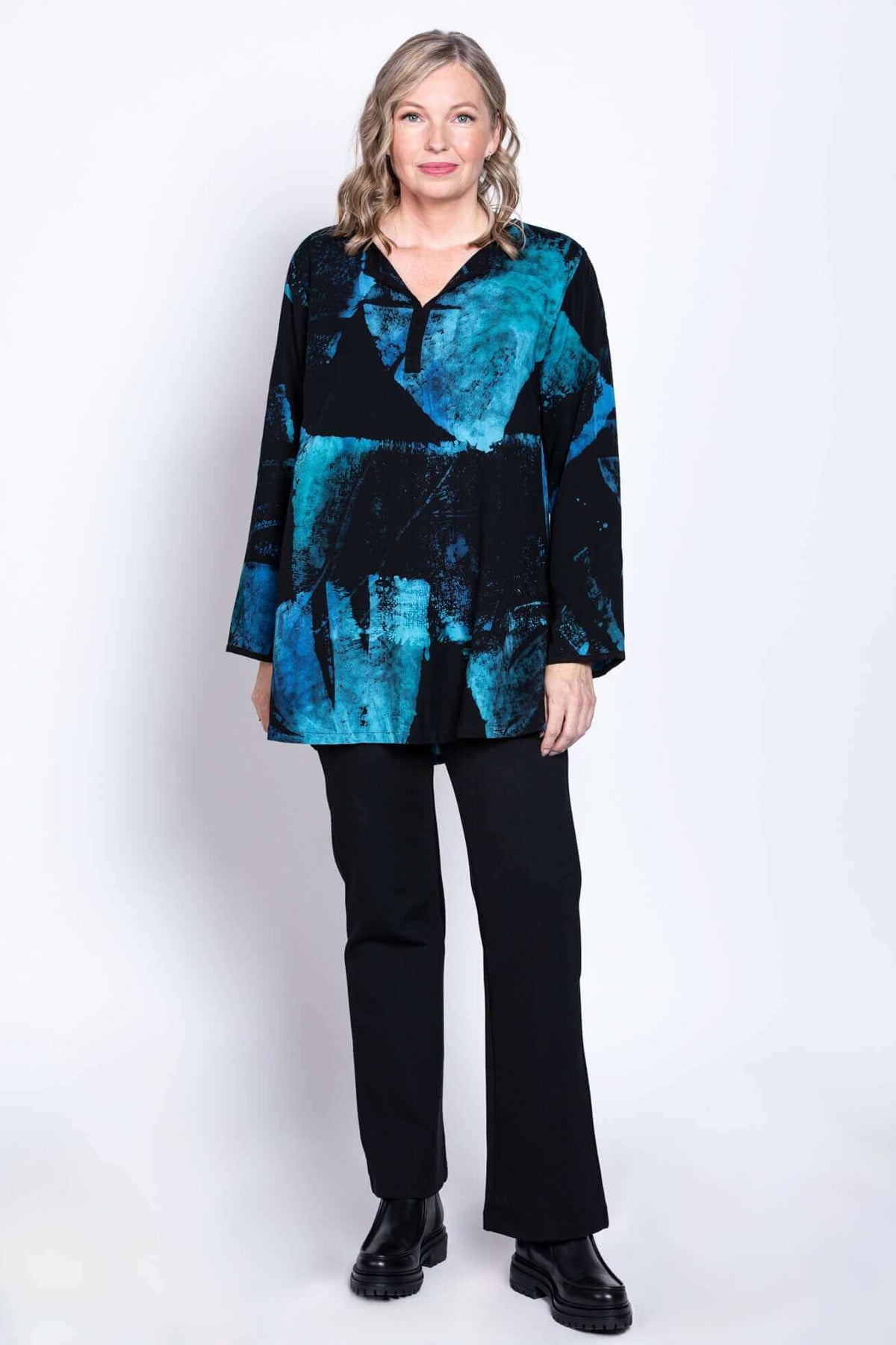 Model in blue and black batik blouse standing front-facing, hands by side