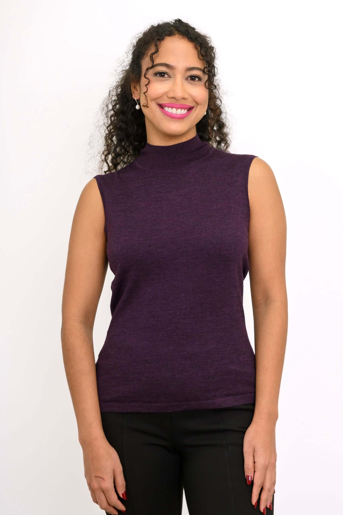 Front-on view of a purple sleeveless mock neck merino wool sweater on a woman