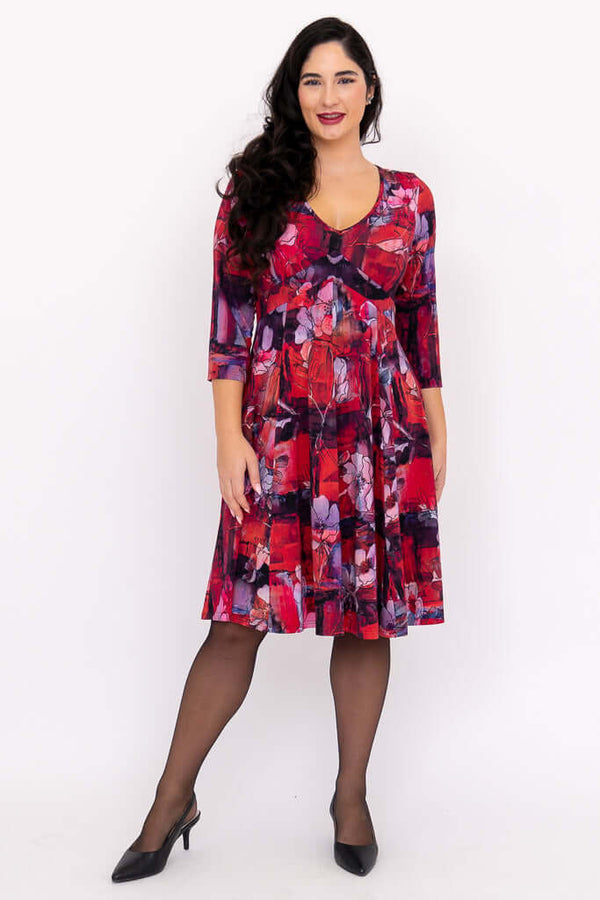 Front view of woman wearing a crimson floral fit and flare dress with 3/4 sleeves