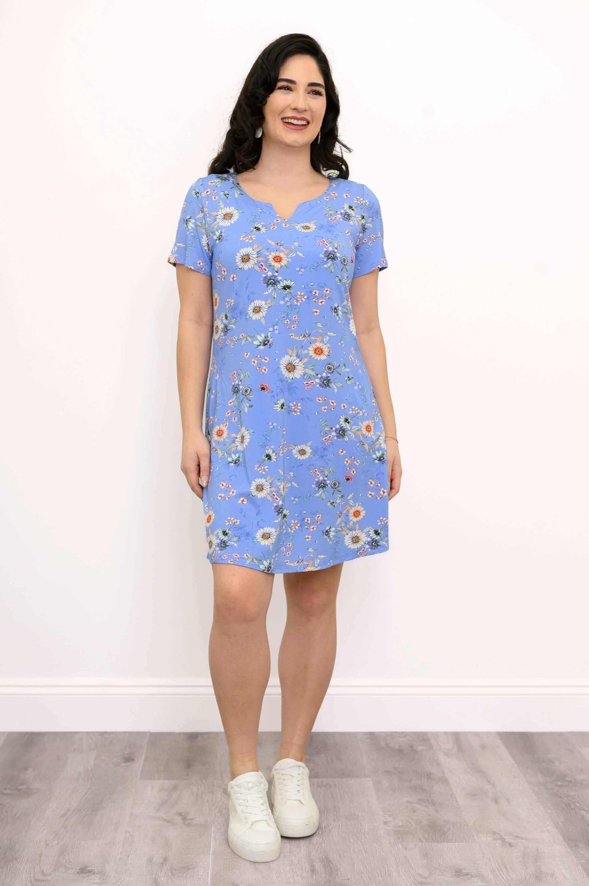 Front view of blue floral short sleeve shift dress paired with white sneakers