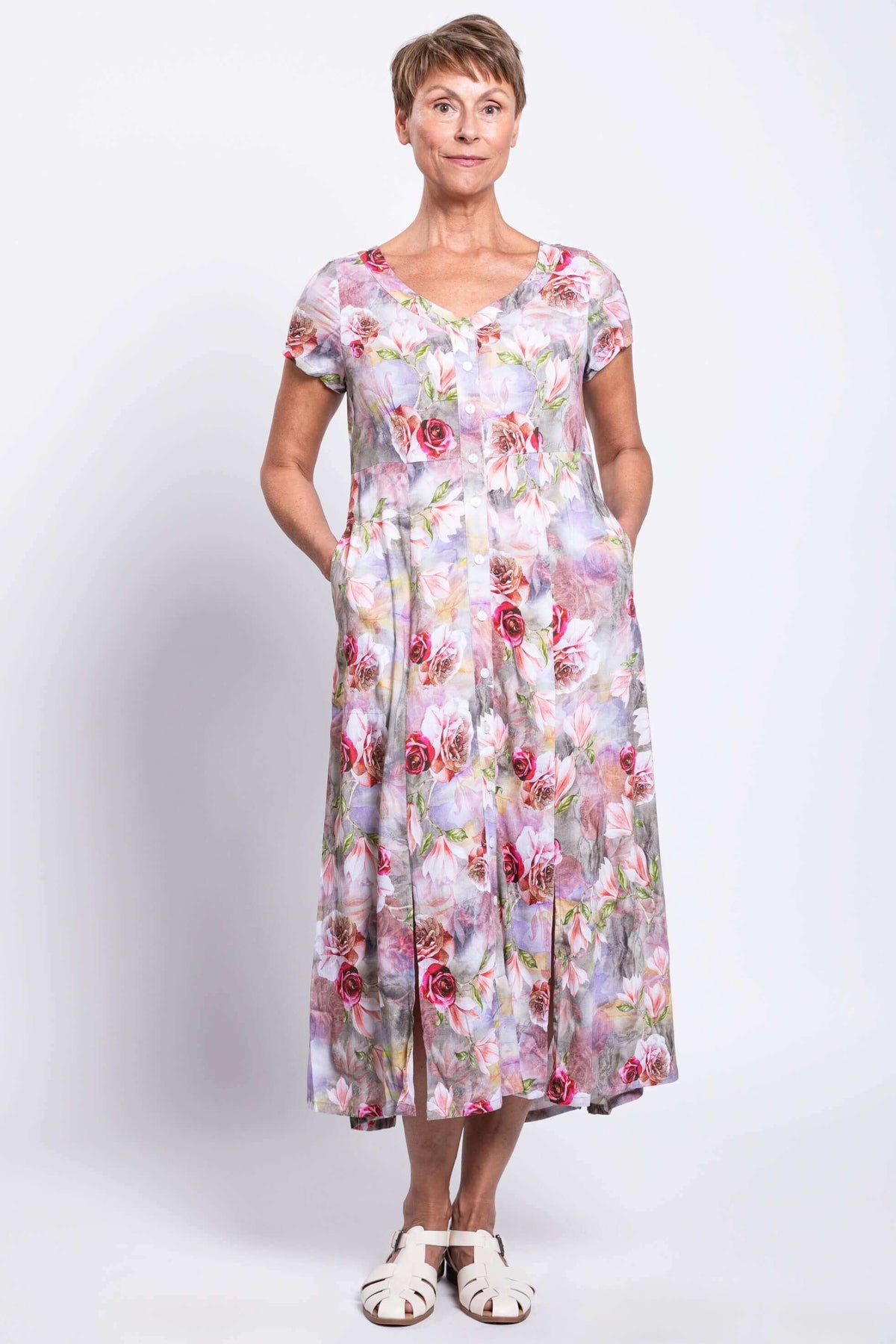 Front angled view of woman wearing a floral panel dress with pockets