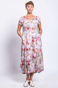 Front angled view of woman wearing a floral panel dress with pockets