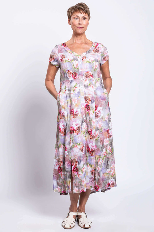 Front angled view of woman wearing a floral panel dress with pockets