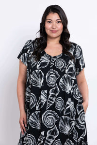 Close-up front view of a woman in the Noosa dress with shell pattern and pockets