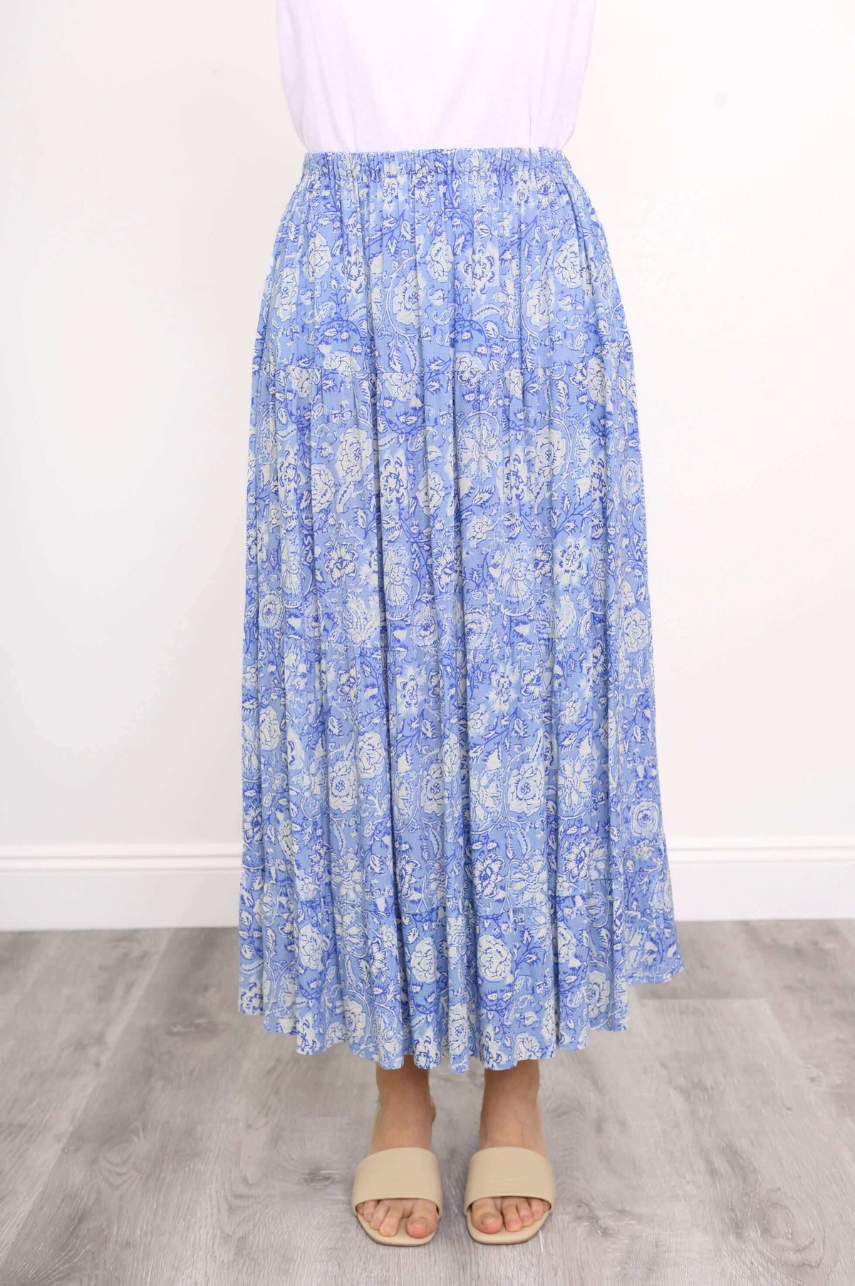 Front view of a blue floral tiered maxi skirt with elastic waist